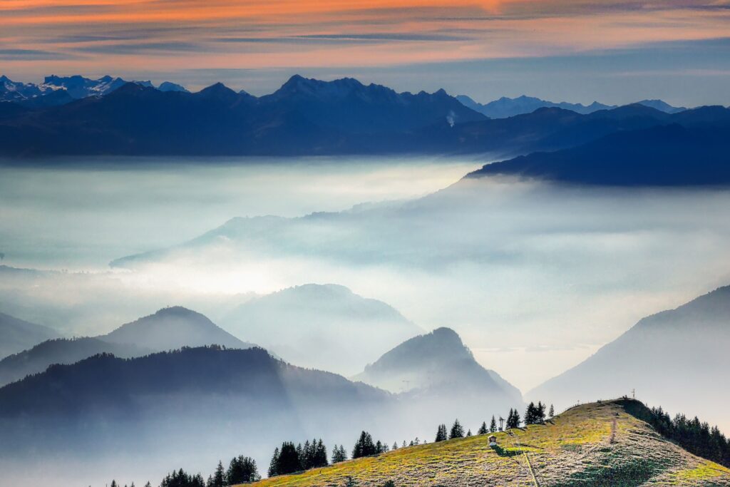 Snow-capped mountain peaks rising above a sea of clouds, symbolizing vision and perspective